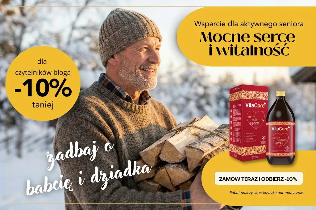 Uśmiechnięty senior niosący drewno w zimowej scenerii. Baner promocyjny VitaCore Tonik na serce i witalność – prezent na Dzień Dziadka z rabatem -10%